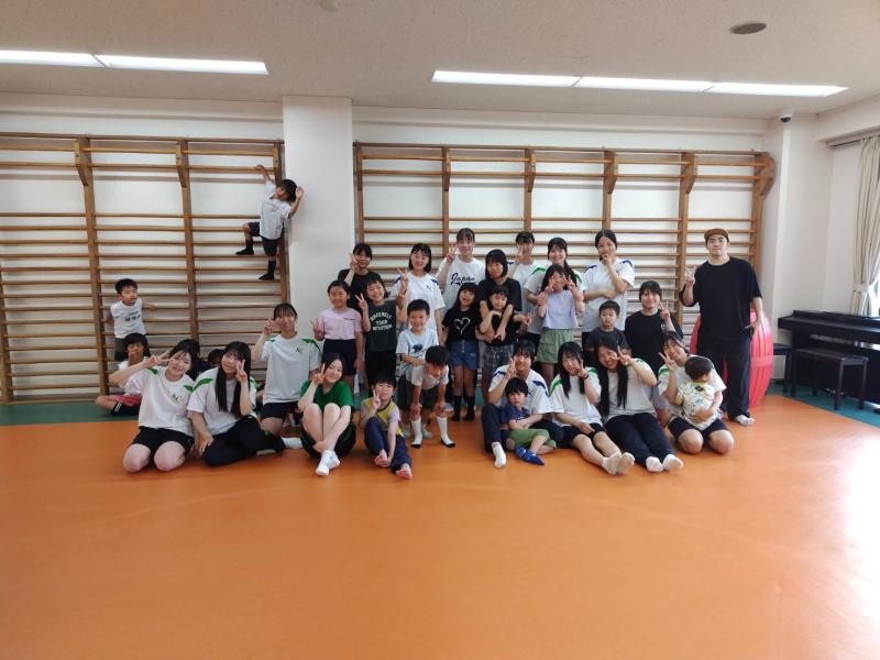 子どもたちとの集合写真に収まる部員たち