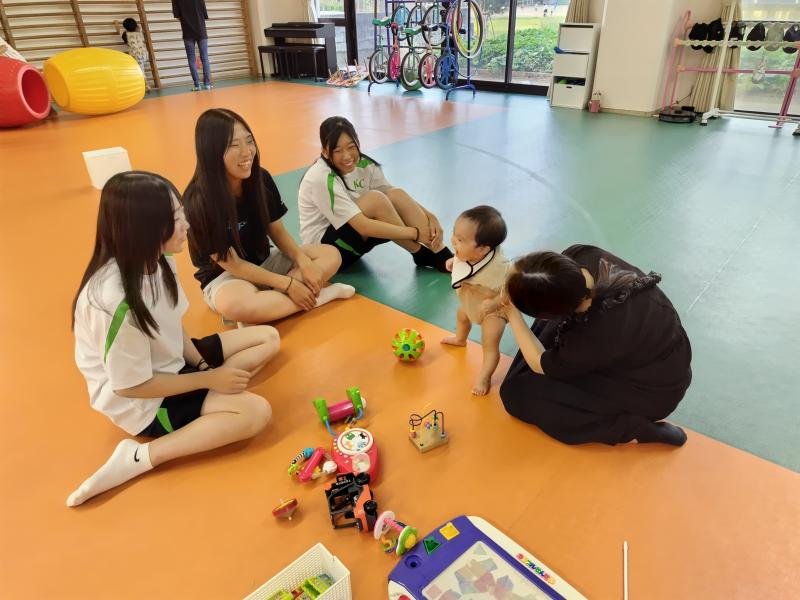 親子連れの子どもと楽しく会話する部員たち