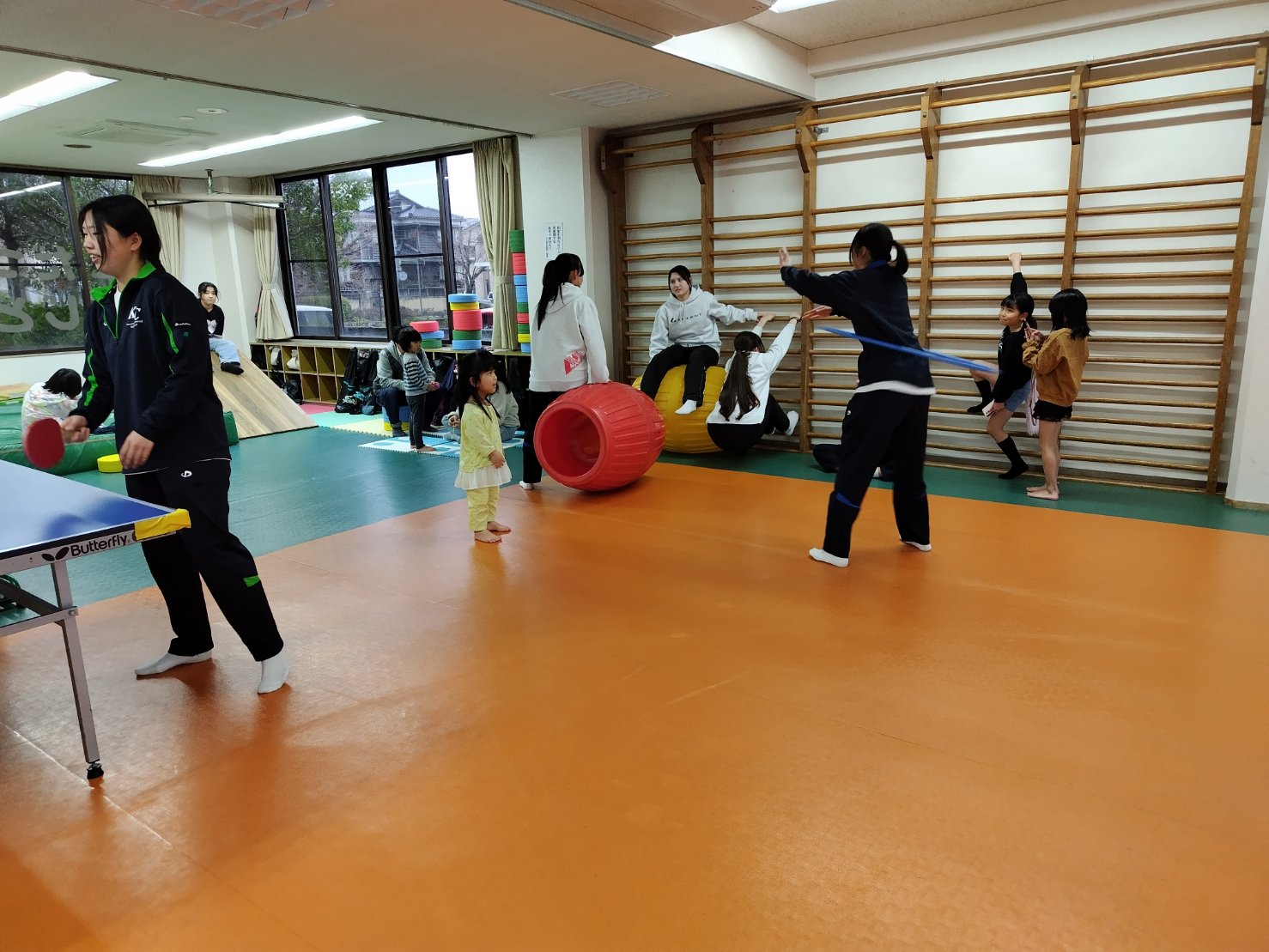 遊具を使った遊びを子どもたちに伝える部員たち